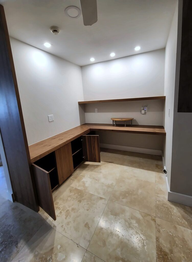 Built-in walnut desk nook with cabinets and recessed lights