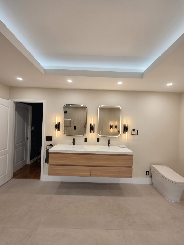 Floating wood double vanity with backlit mirrors and black sconces