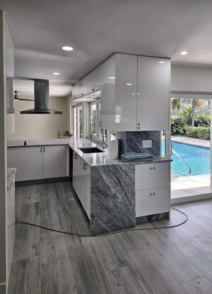 Gloss white kitchen cabinets with a waterfall peninsula