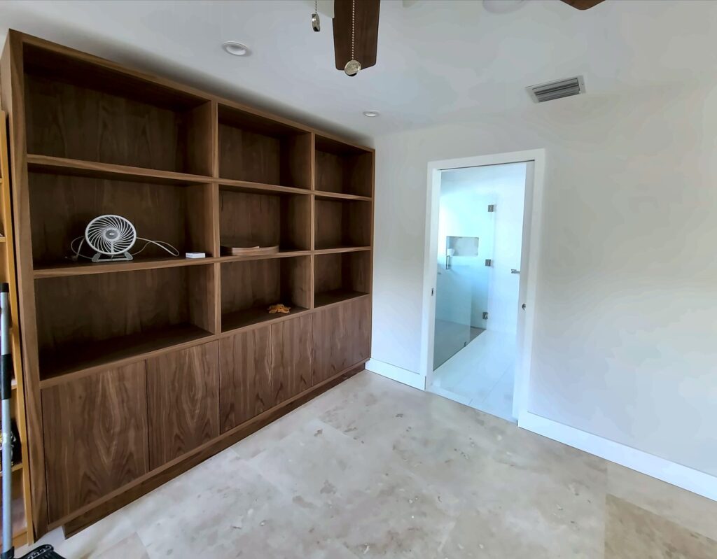 Large-format travertine-look tile floor in an open room with built-in shelves