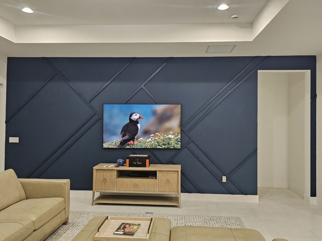 Finished navy geometric molding accent wall behind the TV