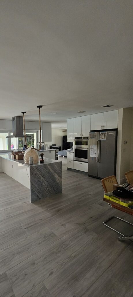 Open living area and kitchen with new vinyl plank flooring and fresh paint