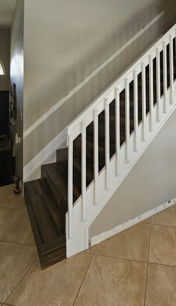 Staircase wall before the picture-frame paneling, plain painted drywall