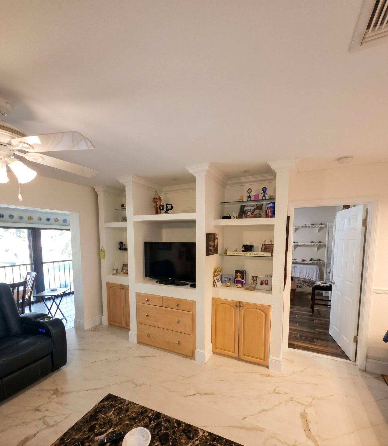 White built-in entertainment center with shelves and wood lower cabinets