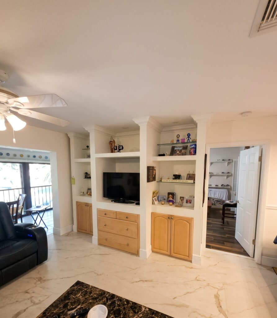 White built-in entertainment center with shelves and wood lower cabinets