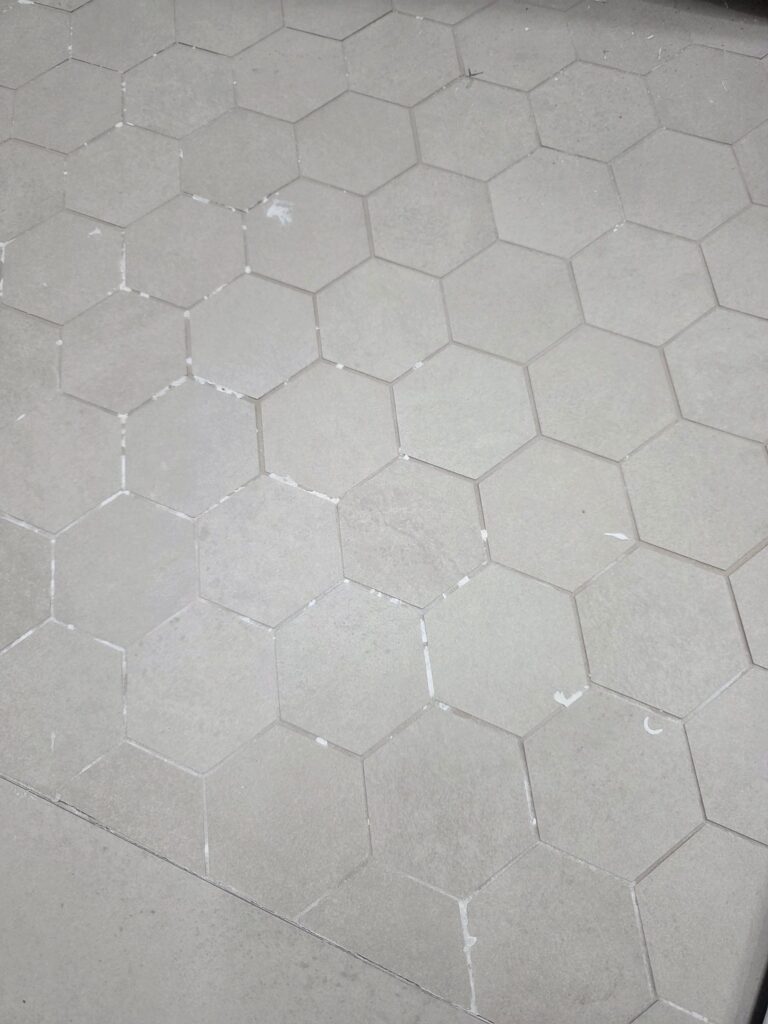 White hexagon mosaic shower floor tile, close-up