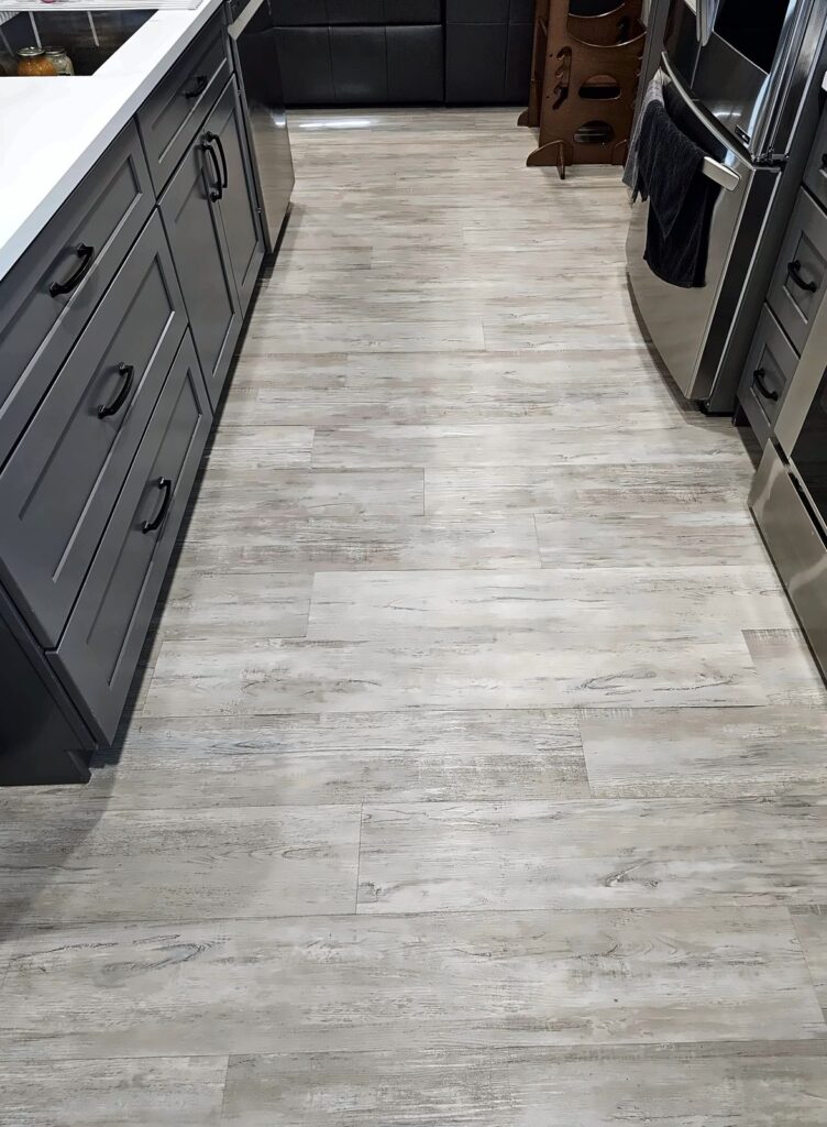 Wood-look tile floor with long straight runs between kitchen cabinets