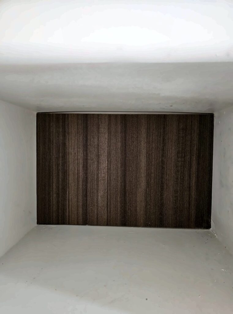 Closet niche finished with a dark wood-slat back panel